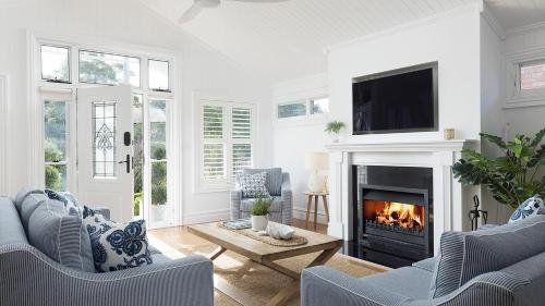 a living room with a fireplace and a tv at The Hamptons Beach House near Dutchie's walk to Nelson Bay in Nelson Bay