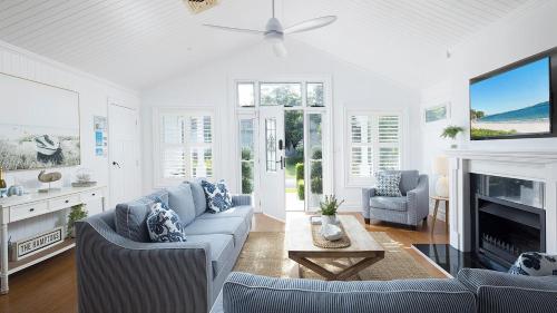 a living room with a couch and a fireplace at The Hamptons Beach House near Dutchie's walk to Nelson Bay in Nelson Bay