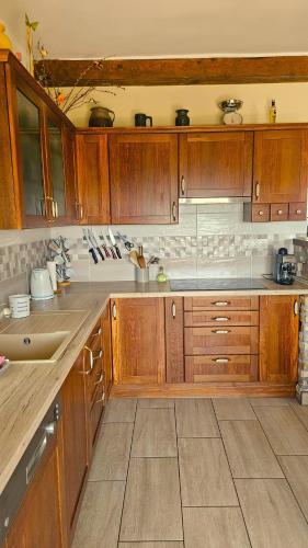 a kitchen with wooden cabinets at Borostyán Ház in Felsőörs