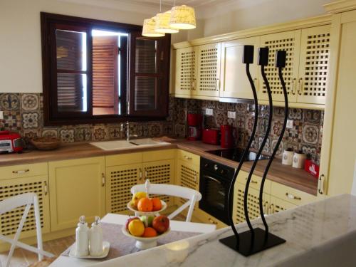 a kitchen with a bowl of fruit on a table at Halkis Muses in Halki