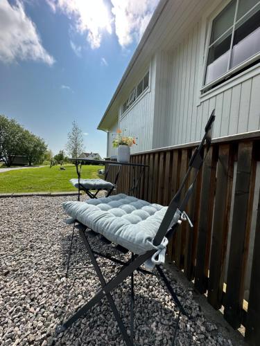 a chair sitting on a patio next to a house at Lofoten Retreat Apartment in Leknes