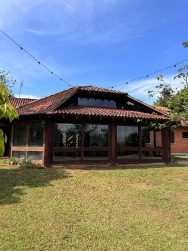 a house with a large window in a yard at Casa de Campo - Espaço Garden in Novo Hamburgo