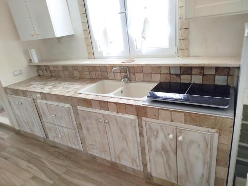 a kitchen with a sink and a counter top at Casa vacanze da Cosimo BEIGE in Porto Cesareo