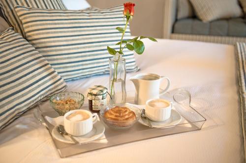 a tray with coffee cups and a vase with a flower at Agromarino in Sirolo
