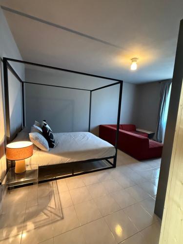a bedroom with a canopy bed and a couch at JR HOME Apuania in Massa