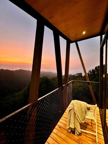 a view from the deck of a tree house at sunset at Casa Bosque Olas de Buchupureo in Cobquecura