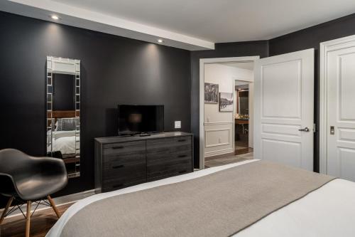 a bedroom with black walls and a bed and a television at Luxury ski-in ski-out condo in St-Sauveur 2 bedrooms in Saint-Sauveur-des-Monts