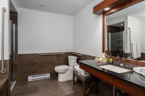 a bathroom with a toilet and a sink and a mirror at Luxury ski-in ski-out condo in St-Sauveur 2 bedrooms in Saint-Sauveur-des-Monts