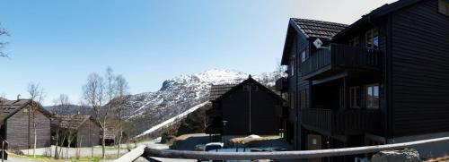 a group of buildings with a snow covered mountain in the background at Skarsnuten Apartments in Hemsedal