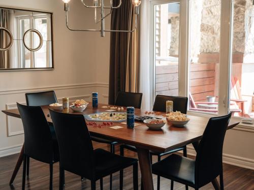 a dining room table and chairs with food on it at Luxury ski-in ski-out condo in St-Sauveur 2 bedrooms in Saint-Sauveur-des-Monts