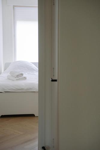 a bedroom with a white bed and a window at Villa Rae in Ostend