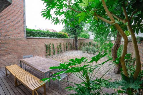 a wooden table and a bench in a garden at Villa Rae in Ostend