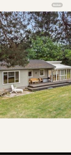 two pictures of a house with a yard at Bøtøstrand feriehus 90 in Marielyst
