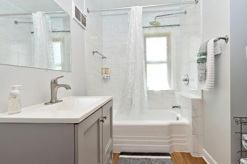 een witte badkamer met een bad en een wastafel bij Spacious 3bdr near 6Flags-Naval Base-Casino in Waukegan