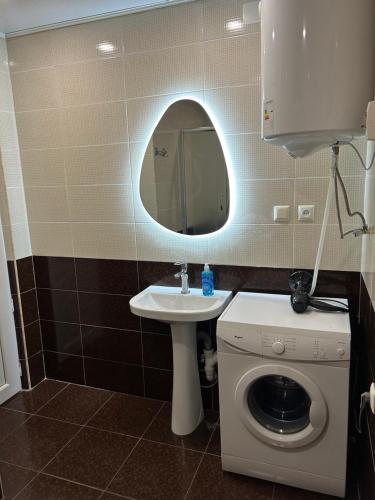 a bathroom with a sink and a washing machine at Green Villa Sea View in Gonio