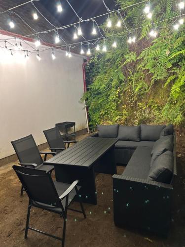 a patio with a couch and a table and chairs at Green Villa Sea View in Gonio