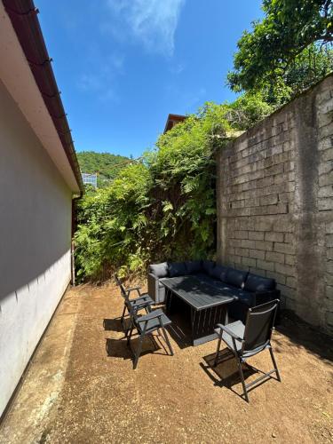 a patio with a black couch and two chairs at Green Villa Sea View in Gonio