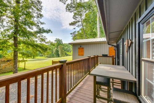 a deck with a table and chairs on a house at 6 Mi to Helen Mtn-View Retreat with Hot Tub! in Clarkesville
