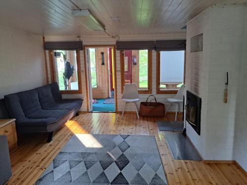 Una sala de estar con un sofá y una chimenea. en Aurora cottage, en Oulu