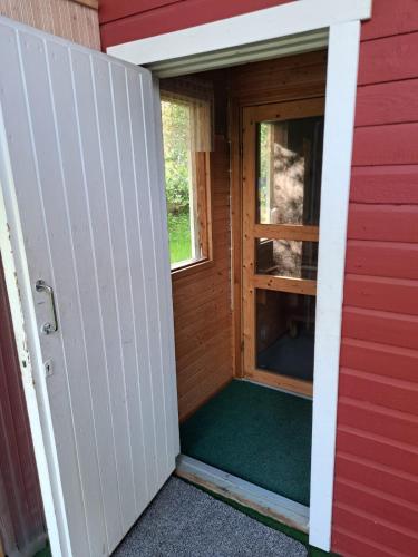 a door to a dog house with a window at Aurora cottage in Oulu