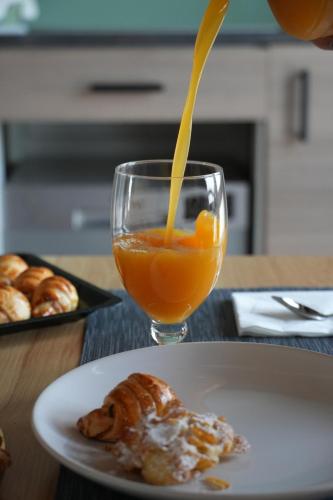 a person pouring an orange juice into a glass at Agriturismo La Fornetta in Ferrara
