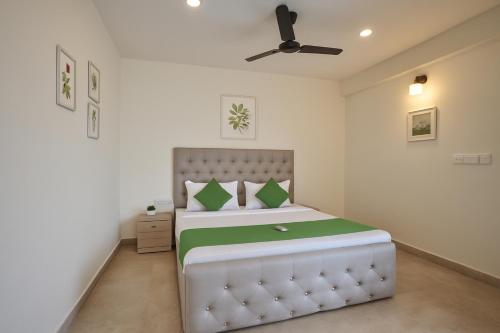 カラングートにあるPhase 369 Casa De Village North Goaのベッドと天井扇風機のある寝室