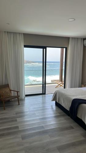 a bedroom with a bed and a view of the ocean at CORAL BAY - Kode Villa in Cidade Velha