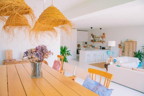 a living room with a wooden table with flowers on it at Just Like Home - Guarda Rios in Linhares