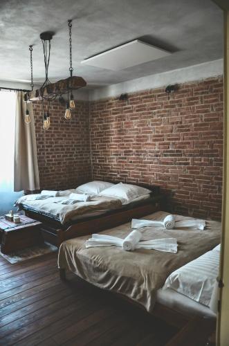 two beds in a room with a brick wall at Apartmány Švejdom dom, centrum Bojnice in Bojnice