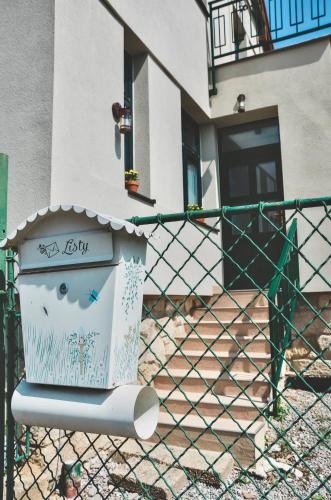 a fence in front of a house with a mailbox at Apartmány Švejdom dom, centrum Bojnice in Bojnice