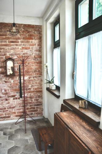 a living room with a brick wall and a television at Apartmány Švejdom dom, centrum Bojnice in Bojnice