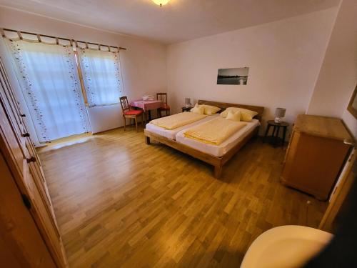 a bedroom with a bed and a wooden floor at Hörterer Martina | Chiemgau Karte in Grassau