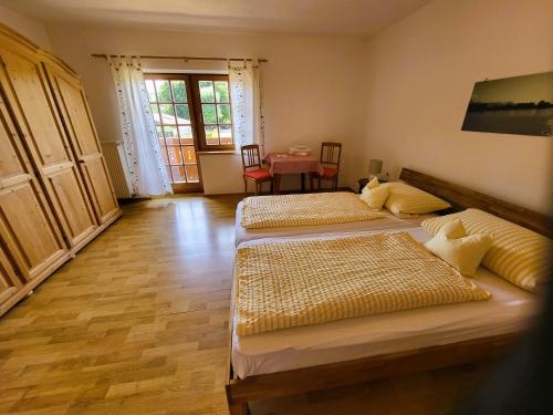 two beds in a room with a table and chairs at Hörterer Martina | Chiemgau Karte in Grassau