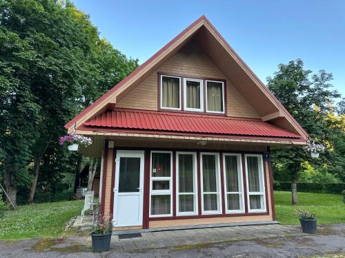 a small house with a red roof at Brīvdienu māja Pūces in Līgatne
