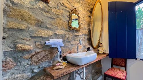 a bathroom with a sink and a stone wall at Segredo da Serra Guest House in Tiradentes