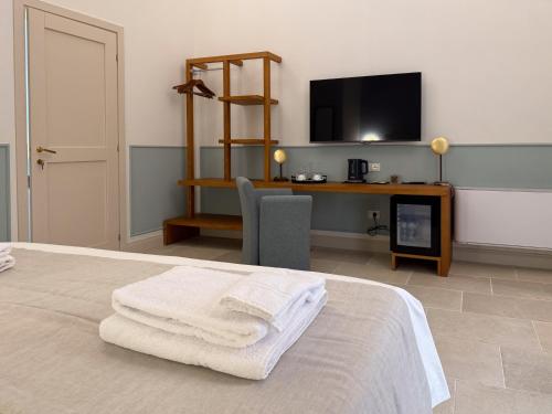 a bedroom with a bed with towels on it at Il Leccio Verde in Lecce
