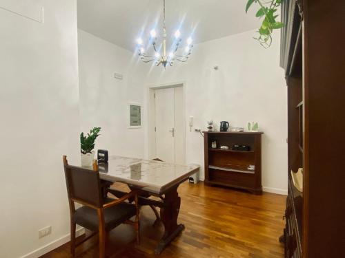 a dining room with a table and a chandelier at Helios Home in Reggio Calabria