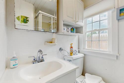 a bathroom with a sink and a toilet and a window at The Genoa in Dennis Port