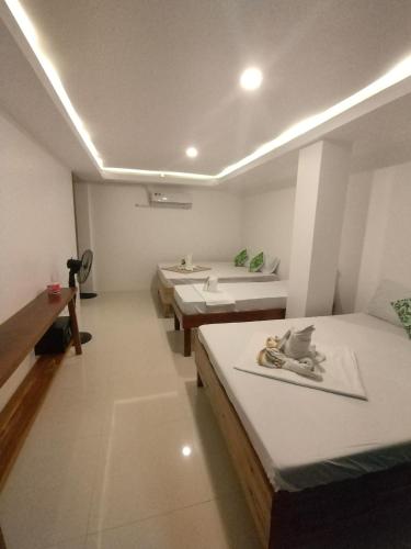 a room with three beds and a sink in it at Joyful Guest House in El Nido