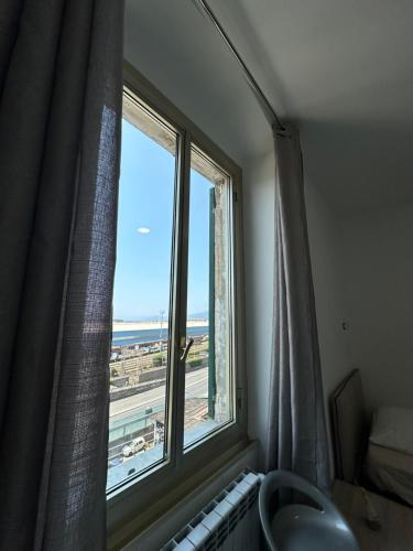 a bathroom with a window with a view of the ocean at Siffredi Rooms in Genova