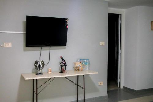 a room with a table with a television on a wall at Maisonabdou in Sousse