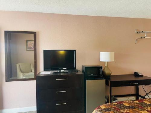 a hotel room with a bedroom with a television and a desk at Finn's Motel in Saint James