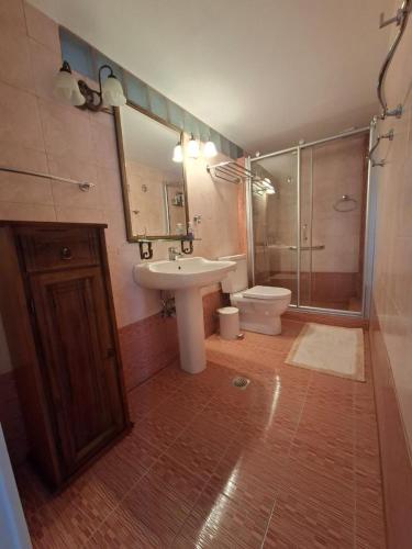 a bathroom with a sink and a shower and a toilet at Captain's House in Plomarion