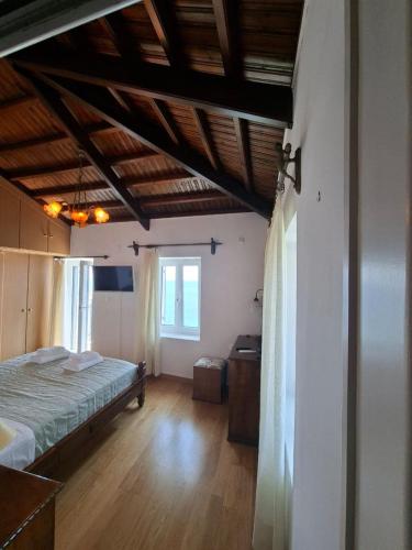 a bedroom with a bed and a wooden floor at Captain's House in Plomarion