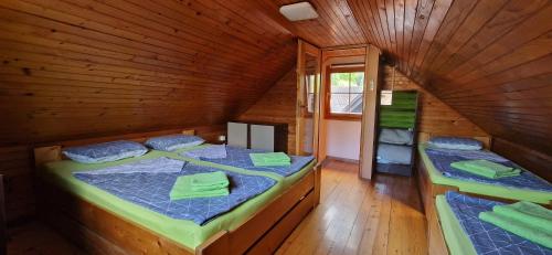 a room with two beds in a wooden cabin at Arijela - hiška v Čatežu 6-1 - Oaza sprostitve v Termah Čatež in Brežice
