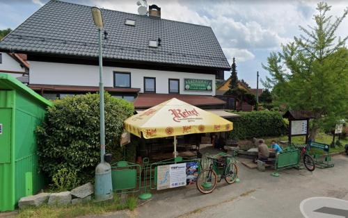 a food stand with a yellow umbrella in front of a house at Solo tábořiště, kemp u vody, Nová Živohošť in Křečovice