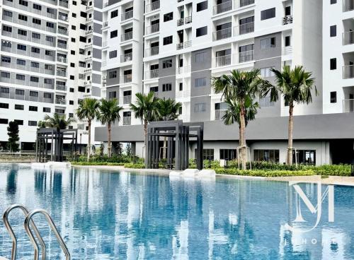 a large swimming pool with palm trees in front of a building at C180 Family Suite Trader Park #22 in Cheras