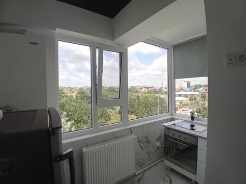 una cucina con due finestre, un lavandino e un bancone di Cazare la mare Stefan a Mamaia Nord - Năvodari