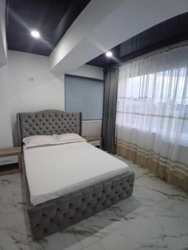 una camera da letto con un letto in una stanza con una finestra di Cazare la mare Stefan a Mamaia Nord - Năvodari