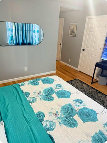 a bedroom with a bed with a blue and white blanket at Luxurious, Spacious, Modern 6 BR Escape with parkings and sleeps up to 16 in Irvington